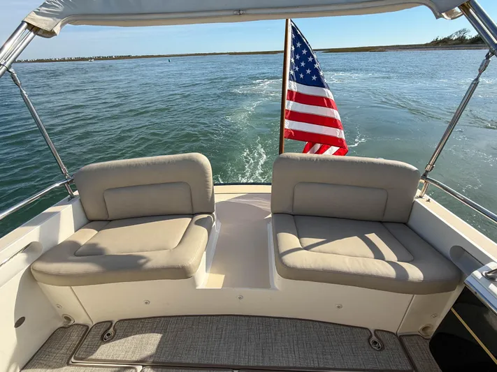 Wild Rose Yacht Photos Pics 2015 MJM 36z Downeast boat with American flag, beige seating, and ocean view.