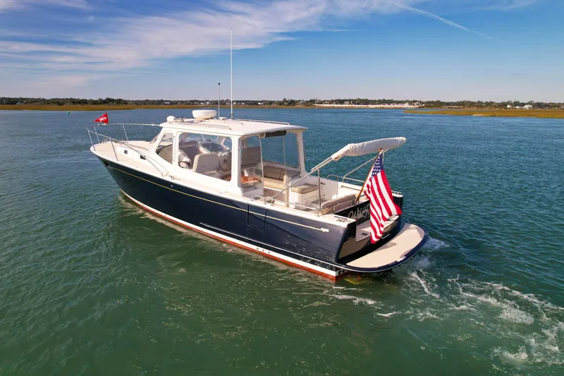 Wild Rose Yacht Photos Pics 2015 MJM 36z Downeast boat cruising on calm waters with American flag.