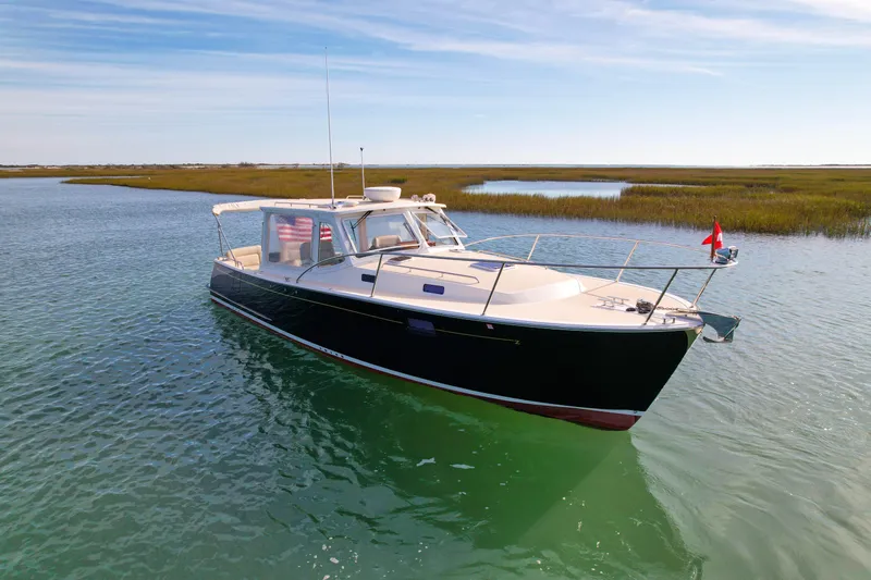 Wild Rose Yacht Photos Pics 2015 MJM 36z Downeast boat on calm water, scenic marshland background.