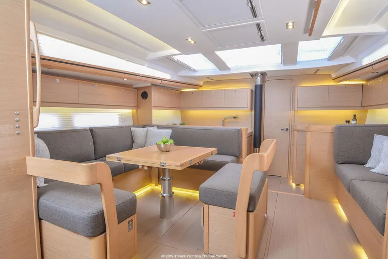  Yacht Photos Pics Interior of 2018 Dufour 520 Grand Large yacht, featuring modern seating and dining area.