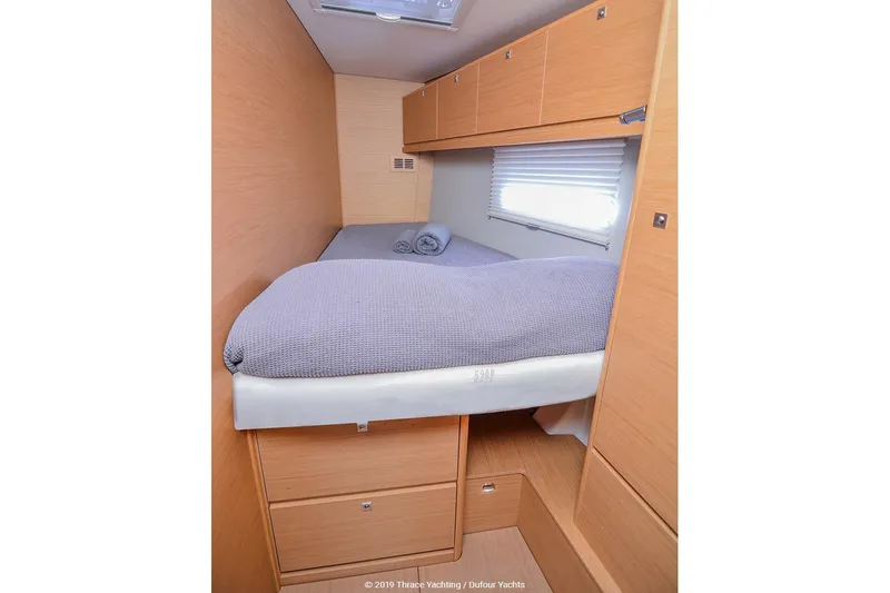  Yacht Photos Pics 2018 Dufour 520 Grand Large yacht cabin with cozy bed and wooden storage.