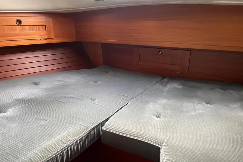  Yacht Photos Pics Cozy cabin interior of 1990 Hallberg-Rassy 36 sailboat with wooden accents and cushioned seating.