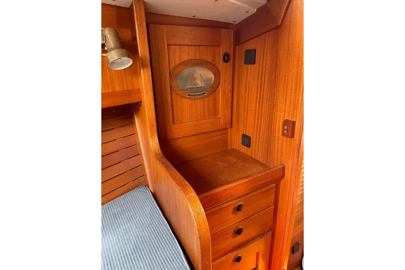 Yacht Photos Pics Interior of 1990 Hallberg-Rassy 36 sailboat with wooden cabinetry and porthole.