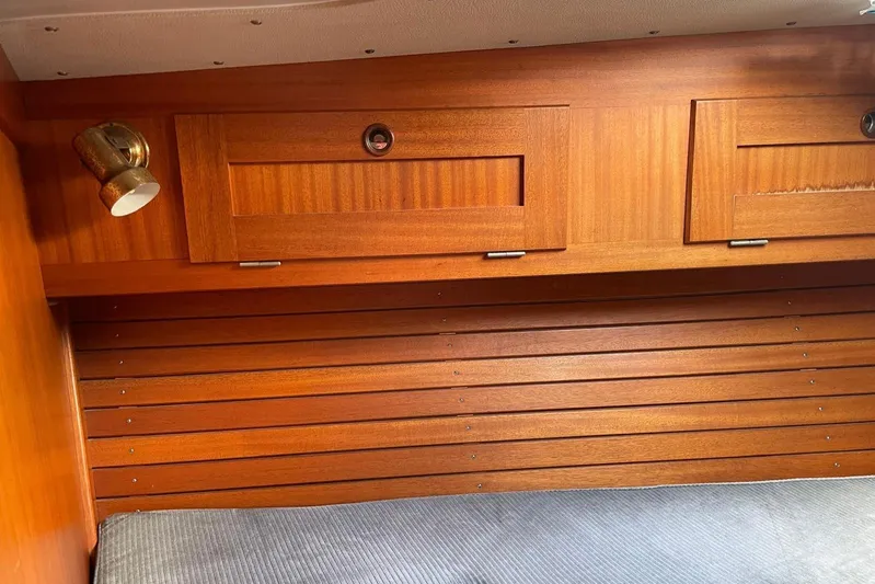  Yacht Photos Pics Interior of 1990 Hallberg-Rassy 36 yacht with wooden cabinetry and brass light fixture.