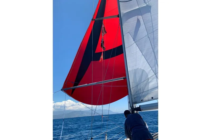  Yacht Photos Pics Sailing on a 1990 Hallberg-Rassy 36 with vibrant red and black sails.