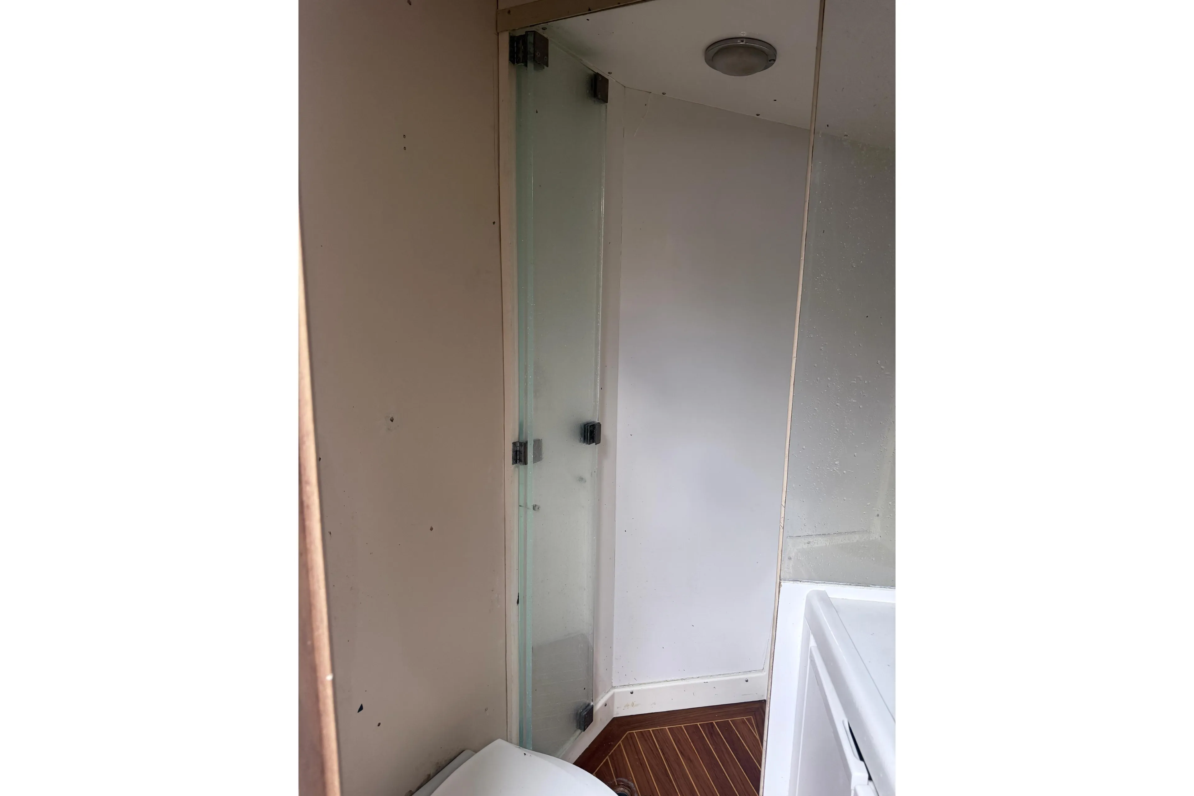Bathroom interior of 1995 Bertram 46 Moppie yacht with glass shower door.