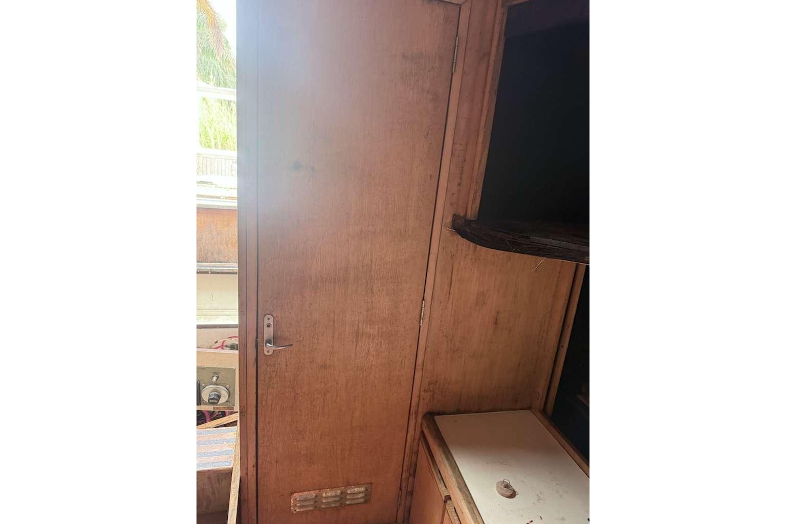 Interior of 1995 Bertram 46 Moppie boat with wooden door and cabinetry.
