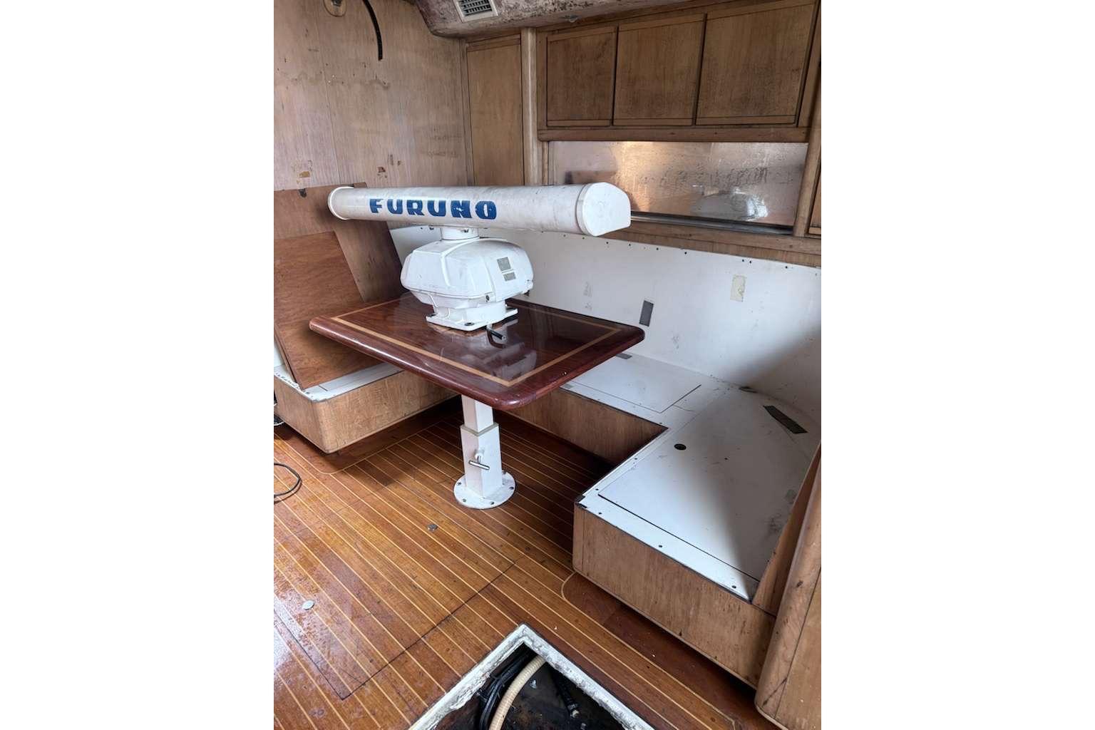 1995 Bertram 46 Moppie interior with wooden flooring and Furuno radar equipment.