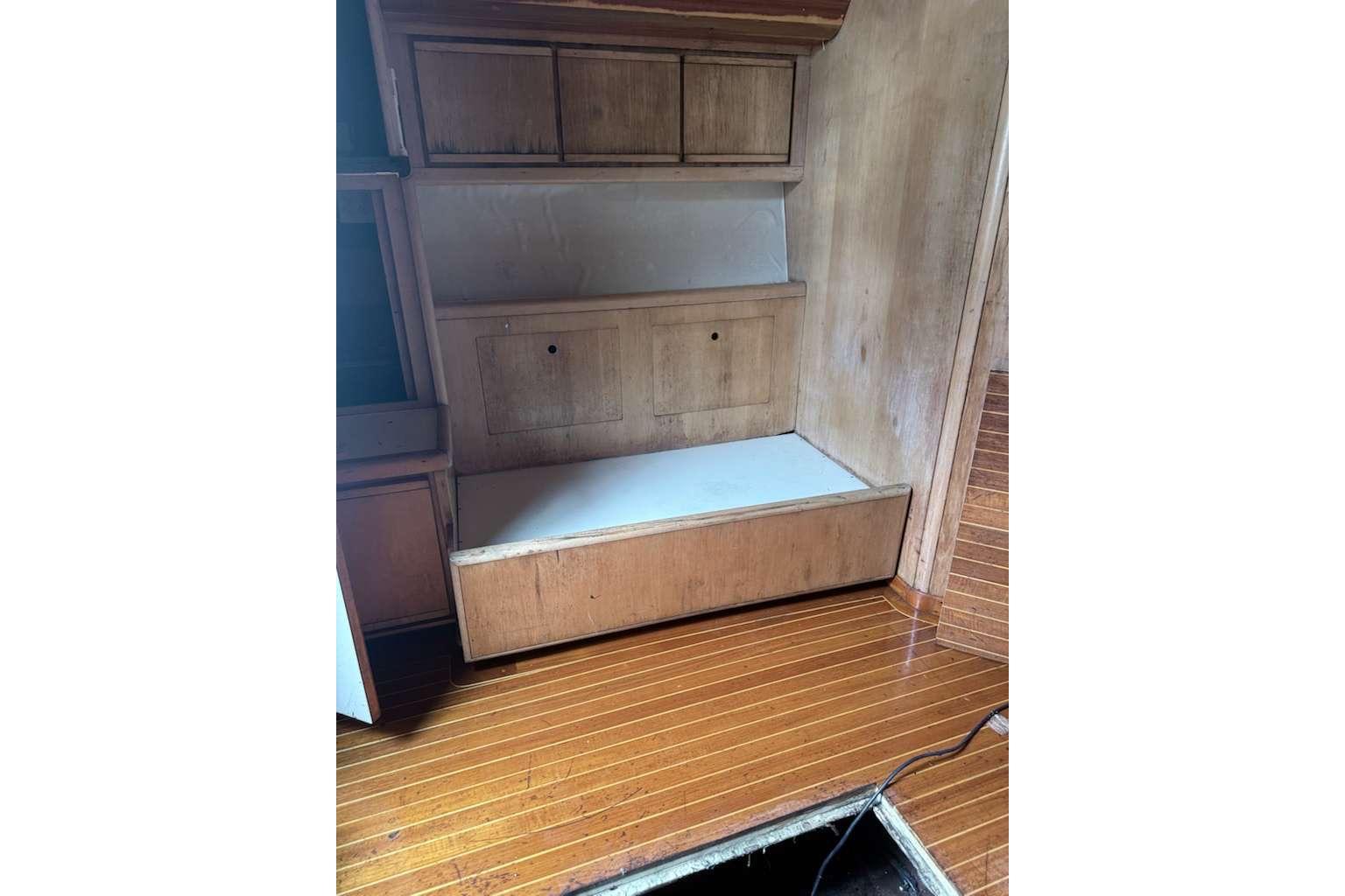 Interior of 1995 Bertram 46 Moppie boat with wooden cabinetry and flooring.