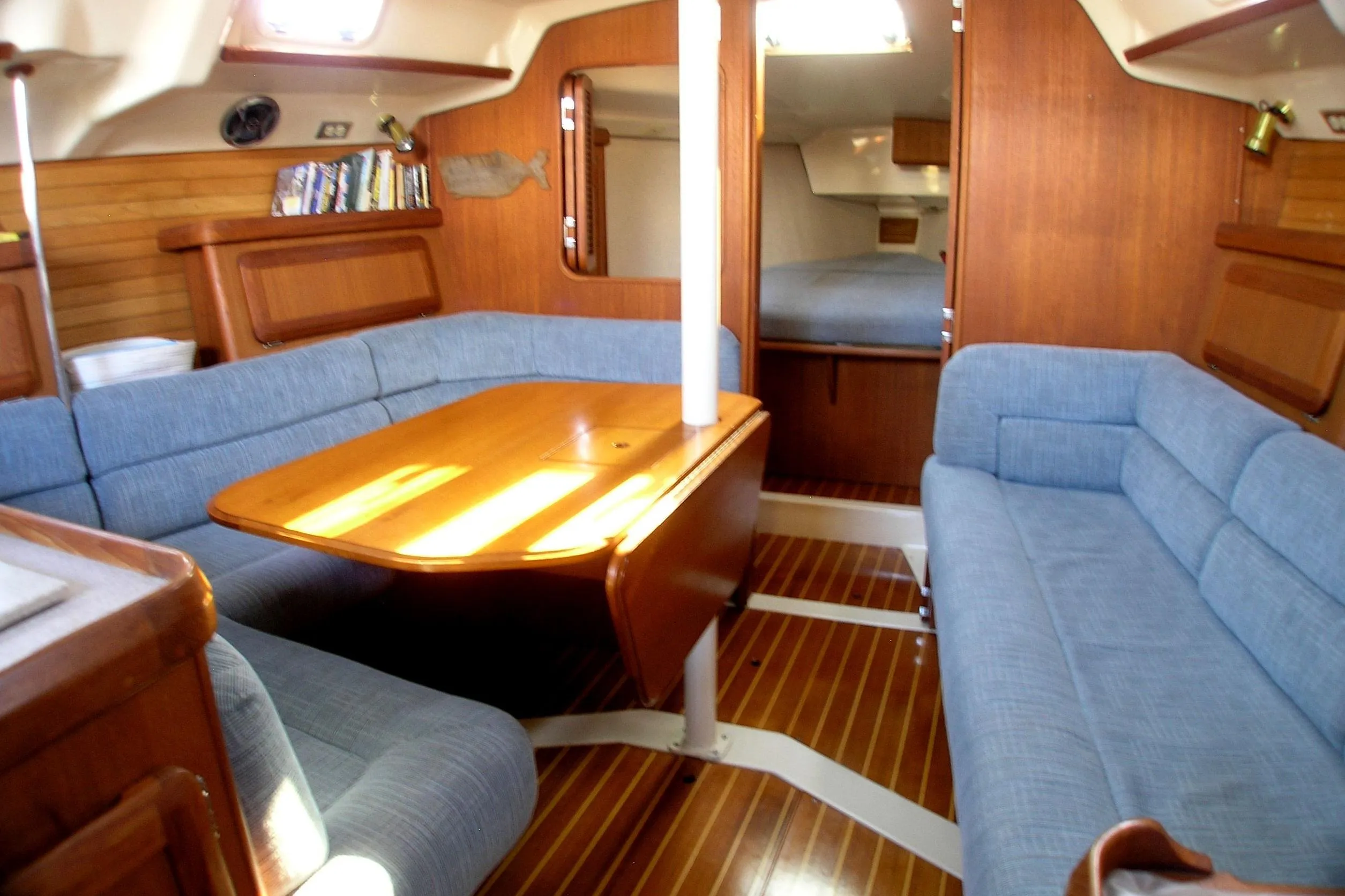 Interior of 1996 Hunter 37.5 Legend sailboat with blue seating and wooden table.