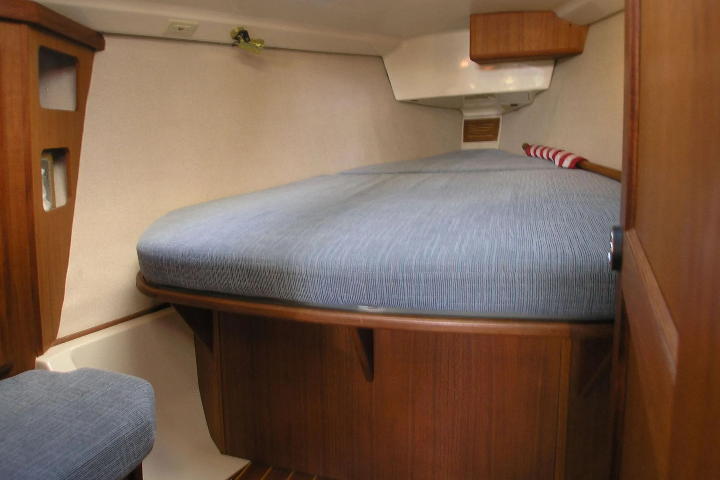 Interior cabin of 1996 Hunter 37.5 Legend sailboat with blue bedding and wooden finish.