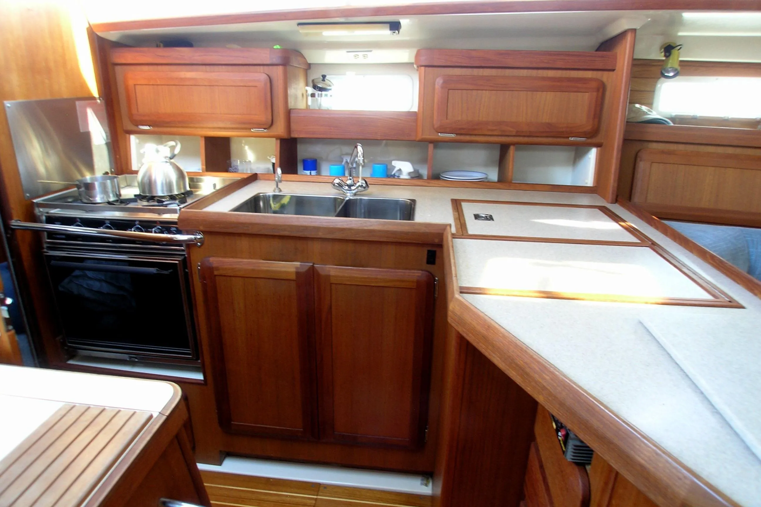 Interior of 1996 Hunter 37.5 Legend yacht kitchen with wooden cabinetry and modern appliances.