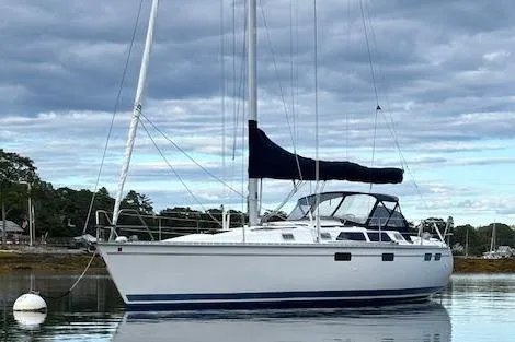 1996 Hunter 37.5 Legend sailboat anchored on calm water with cloudy sky.