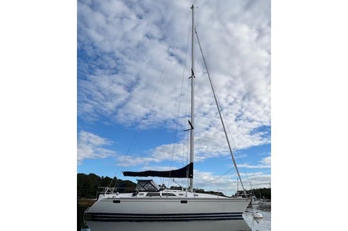 Sailboat Hunter 37.5 Legend 1996 under cloudy sky on calm water.