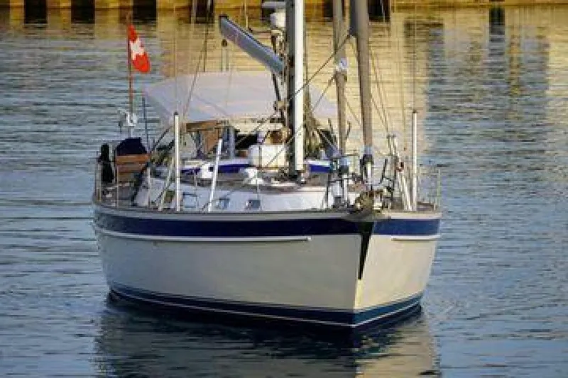 Persistence Yacht Photos Pics Hallberg-Rassy 53 sailboat from 2002 on calm water, featuring a Canadian flag.