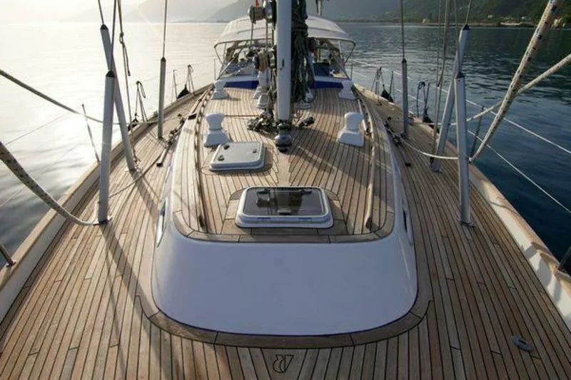 Persistence Yacht Photos Pics Deck view of 2002 Hallberg-Rassy 53 yacht, featuring sleek wooden finish and ocean backdrop.