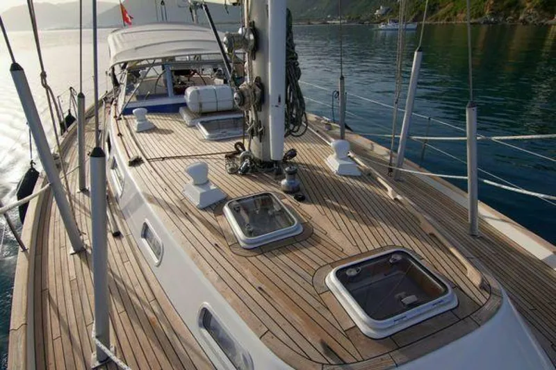 Persistence Yacht Photos Pics Deck view of a 2002 Hallberg-Rassy 53 yacht, featuring teak wood and open hatches.