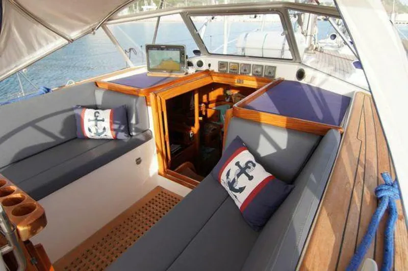Persistence Yacht Photos Pics Luxurious 2002 Hallberg-Rassy 53 yacht cockpit with plush seating and nautical-themed cushions.