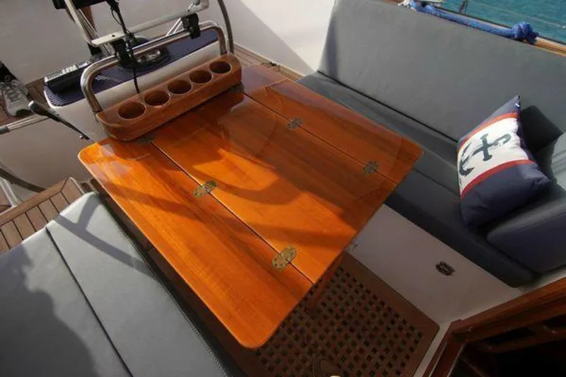 Persistence Yacht Photos Pics Luxurious Hallberg-Rassy 53 yacht cockpit with wooden table and cushioned seating, 2002 model.