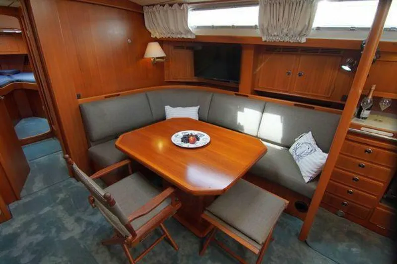 Persistence Yacht Photos Pics Luxurious 2002 Hallberg-Rassy 53 yacht interior with elegant dining area and wooden furnishings.