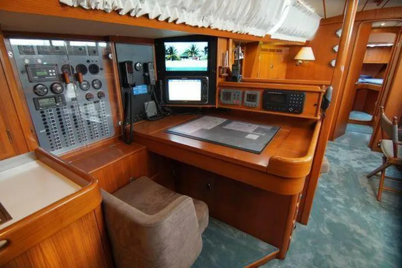 Persistence Yacht Photos Pics Navigation station inside a 2002 Hallberg-Rassy 53 yacht, featuring control panels and monitors.
