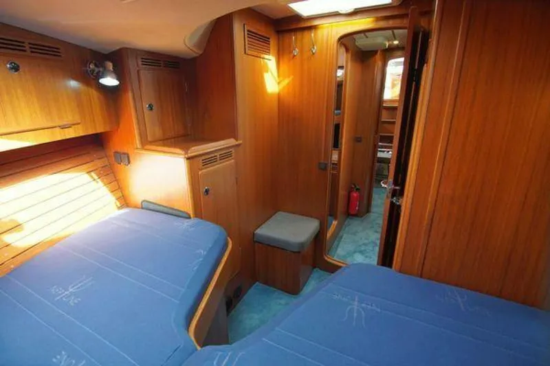 Persistence Yacht Photos Pics Interior of 2002 Hallberg-Rassy 53 yacht with twin beds and wooden cabinetry.