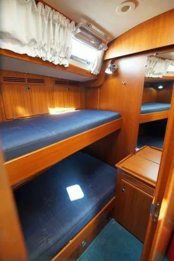 Persistence Yacht Photos Pics Interior of 2002 Hallberg-Rassy 53 yacht with wooden bunk beds and porthole.