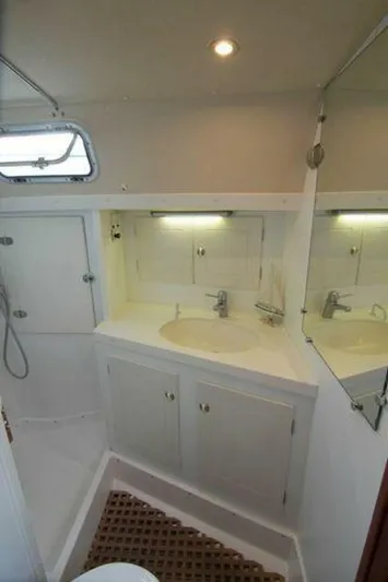Persistence Yacht Photos Pics Bathroom interior of a 2002 Hallberg-Rassy 53 yacht, featuring a sink and mirror.