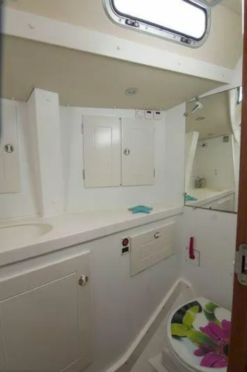 Persistence Yacht Photos Pics 2002 Hallberg-Rassy 53 yacht bathroom with white cabinetry and floral toilet seat.