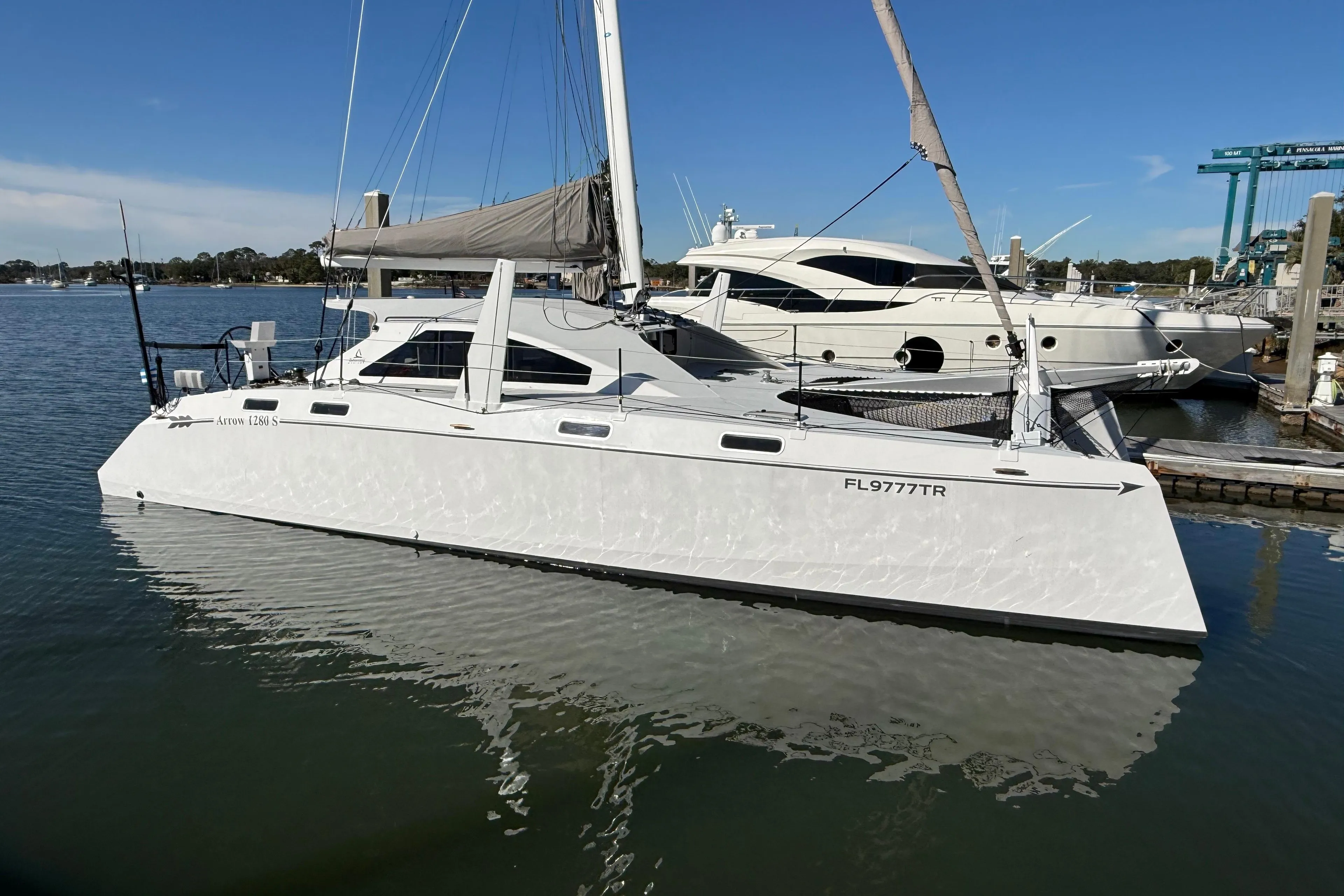2023 Schionning 1850 S catamaran docked in a marina under clear blue skies.