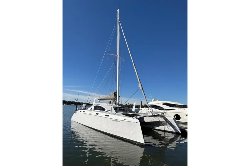  Yacht Photos Pics 2023 Schionning 1850 S catamaran docked on calm water under clear blue sky.