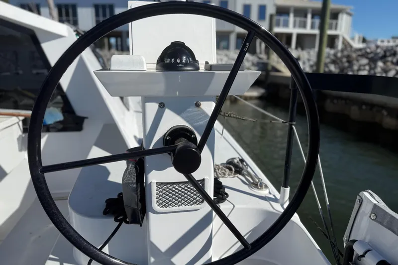  Yacht Photos Pics Steering wheel of 2023 Schionning 1850 S catamaran, docked at marina.