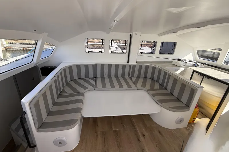  Yacht Photos Pics 2023 Schionning 1850 S interior with striped seating and modern design.