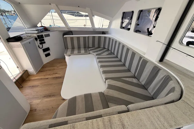  Yacht Photos Pics 2023 Schionning 1850 S interior with striped seating and wooden flooring.