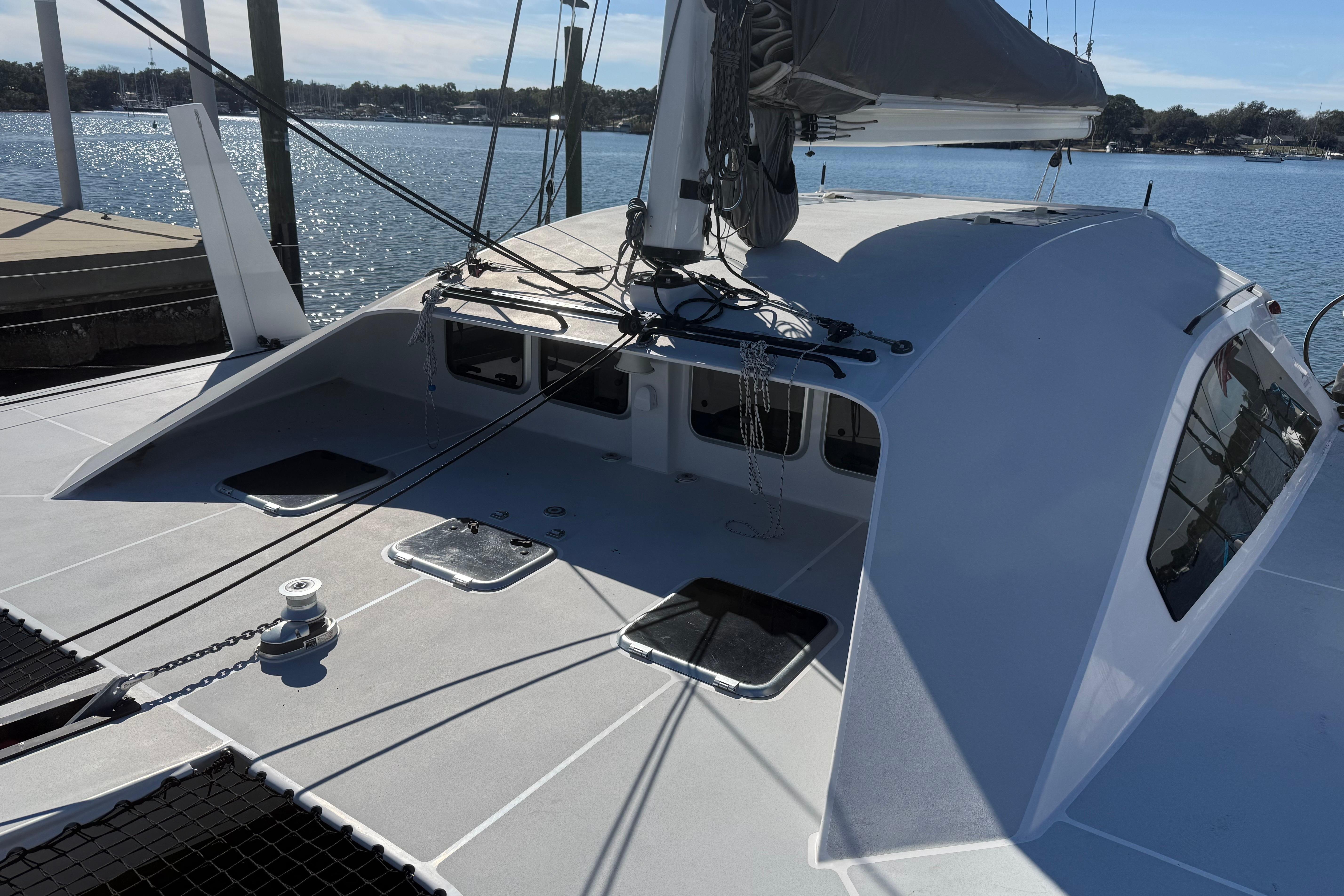 Modern 2023 Schionning 1850 S catamaran docked by the water.