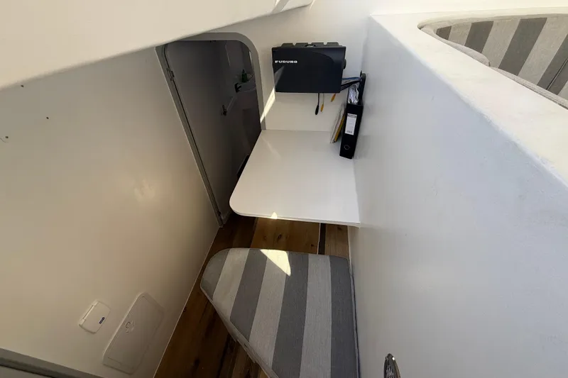  Yacht Photos Pics Compact workspace in 2023 Schionning 1850 S yacht with striped seating and white desk.