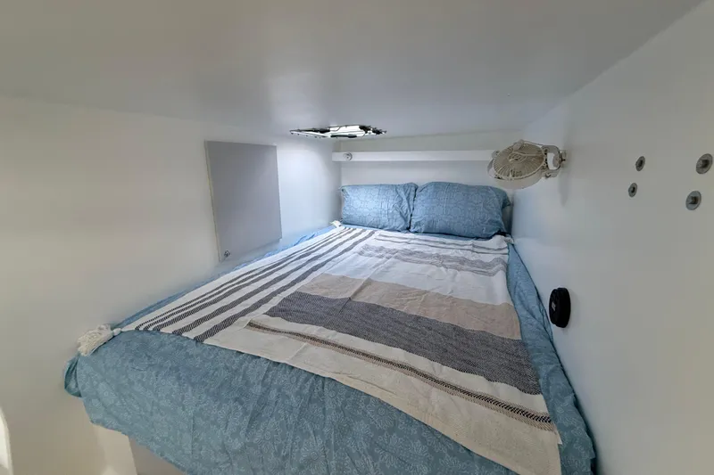  Yacht Photos Pics Cozy cabin interior of 2023 Schionning 1850 S with a neatly made bed.