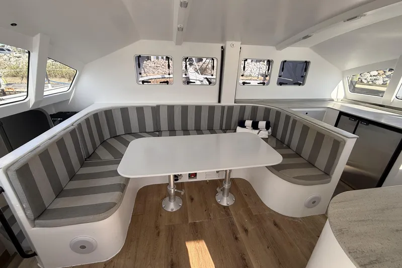  Yacht Photos Pics Modern interior of 2023 Schionning 1850 S catamaran with striped seating and sleek design.