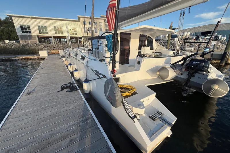  Yacht Photos Pics 2023 Schionning 1850 S catamaran docked at marina, showcasing sleek design and modern features.