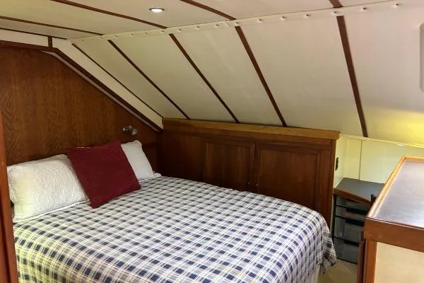 Island Hopper Yacht Photos Pics Cozy cabin interior of 2001 Crosswater Passagemaker 49 with plaid bedding and wooden accents.