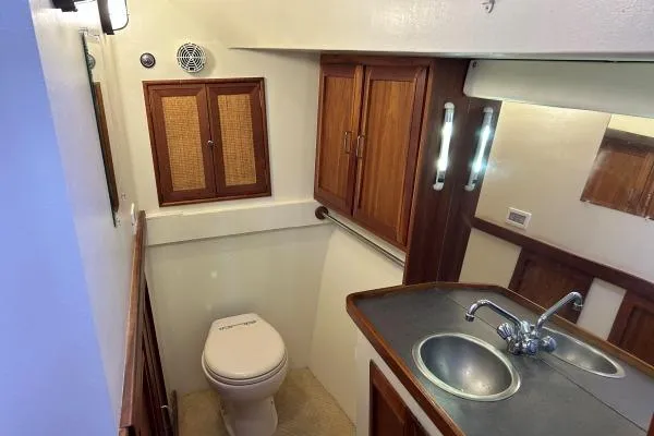 Island Hopper Yacht Photos Pics Bathroom interior of 2001 Crosswater Passagemaker 49 with wooden cabinets and sink.