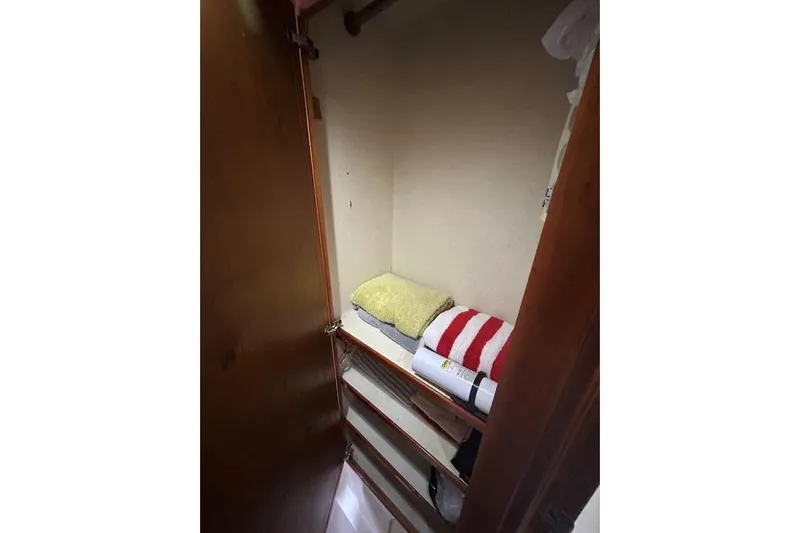 Island Hopper Yacht Photos Pics Small storage closet with shelves and folded towels on a 2001 Crosswater Passagemaker 49.