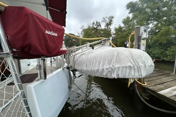 Island Hopper Yacht Photos Pics 2001 Crosswater Passagemaker 49 docked with covered equipment and trees in the background.