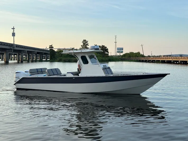  Yacht Photos Pics Custom 2003 Leblanc CC boat on calm water near a bridge at sunset.
