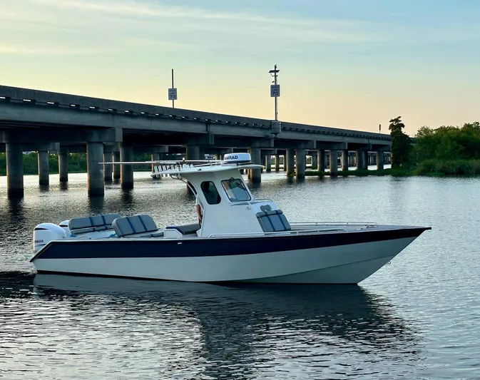  Yacht Photos Pics Custom 2003 Leblanc CC boat on calm water near a bridge at sunset.