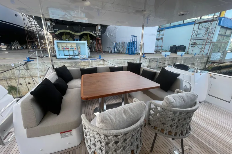 Azimut 66 Magellano Yacht Photos Pics Luxurious seating area on 2024 Azimut Magellano 66 yacht, featuring elegant cushions and wooden table.