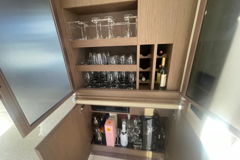 Azimut 66 Magellano Yacht Photos Pics Luxury bar cabinet on 2024 Azimut Magellano 66 yacht, featuring glassware and wine storage.