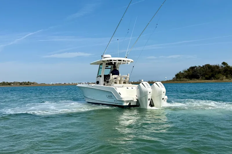  Yacht Photos Pics 2024 Boston Whaler 250 Outrage boat cruising on clear blue water.