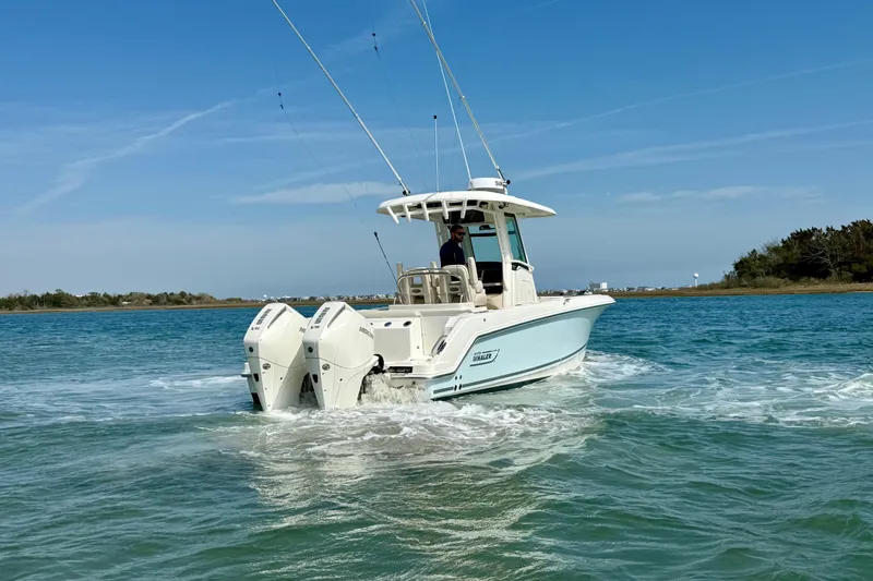  Yacht Photos Pics 2024 Boston Whaler 250 Outrage boat cruising on clear blue water.