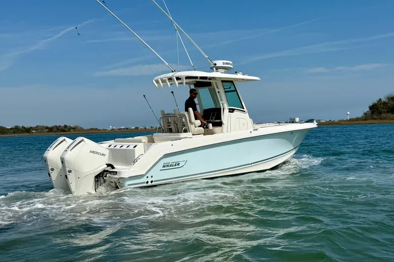  Yacht Photos Pics 2024 Boston Whaler 250 Outrage boat cruising on clear blue water.
